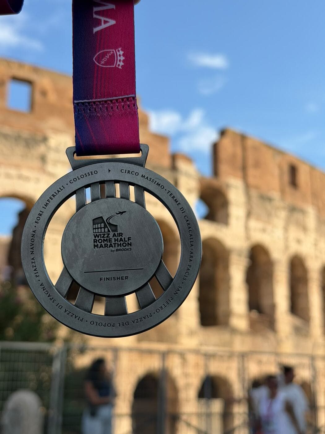 La médaille de finisher du semi-marathon de Rome devant le Colisée