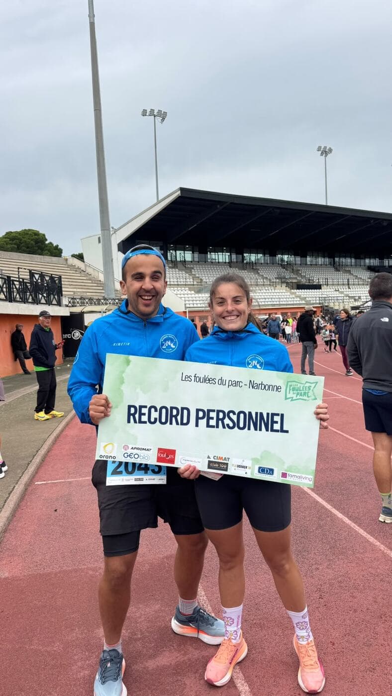 Coureurs du Narbo Nordik Club posant avec le panneau « Record personnel » sur la piste du stade, photo 1 sur 12