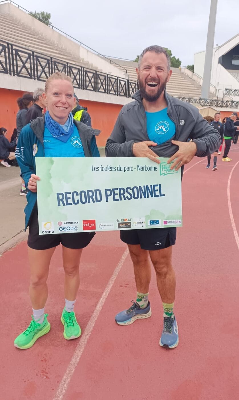 Coureurs du Narbo Nordik Club posant avec le panneau « Record personnel » sur la piste du stade, photo 6 sur 12