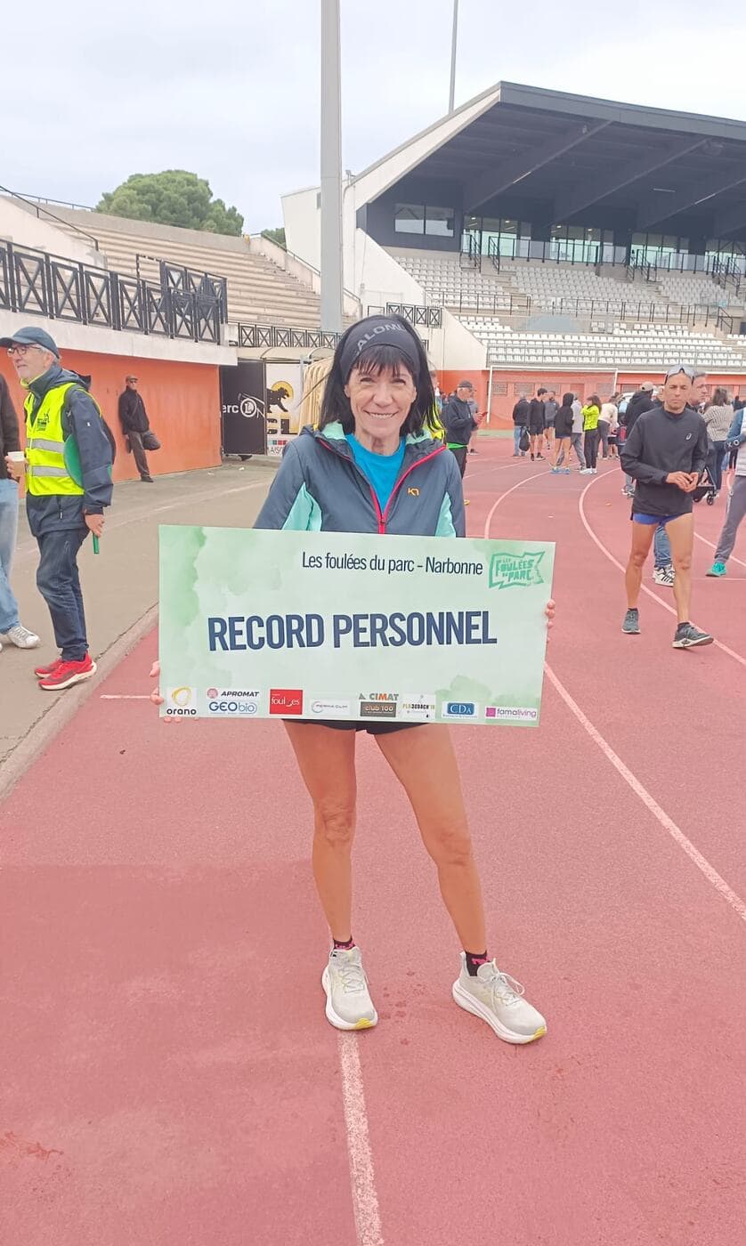 Coureurs du Narbo Nordik Club posant avec le panneau « Record personnel » sur la piste du stade, photo 10 sur 12