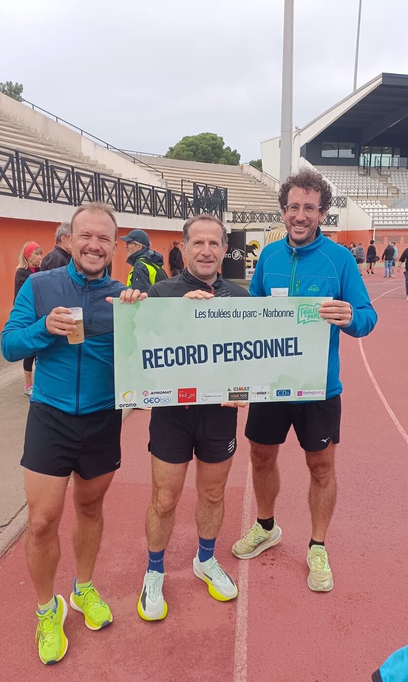 Coureurs du Narbo Nordik Club posant avec le panneau « Record personnel » sur la piste du stade, photo 11 sur 12