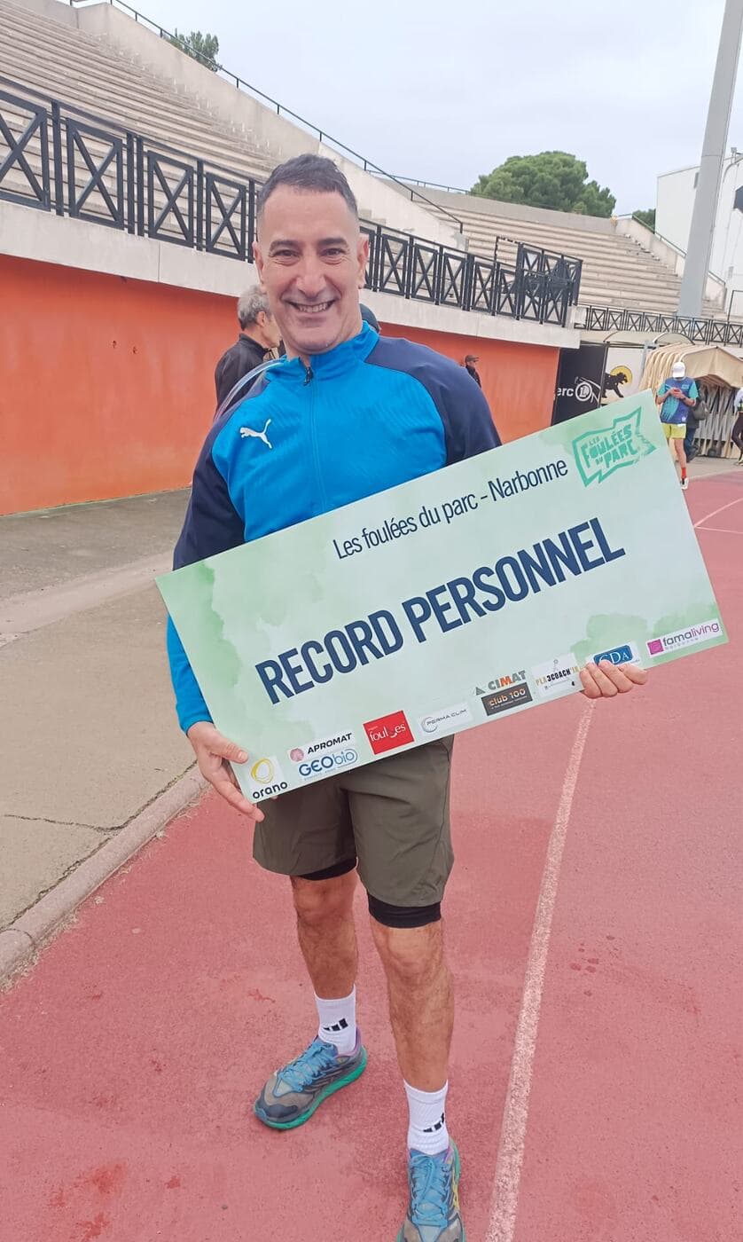 Coureurs du Narbo Nordik Club posant avec le panneau « Record personnel » sur la piste du stade, photo 12 sur 12