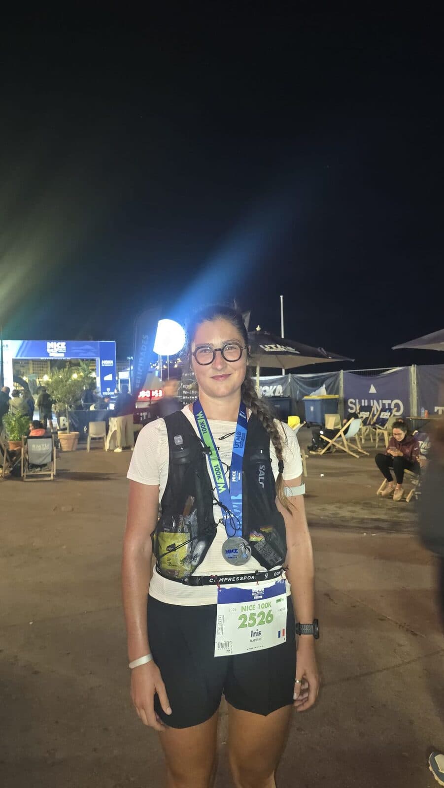 Iris de nuit sur l'aire d'arrivée de Nice by UTMB, médaille autour du cou