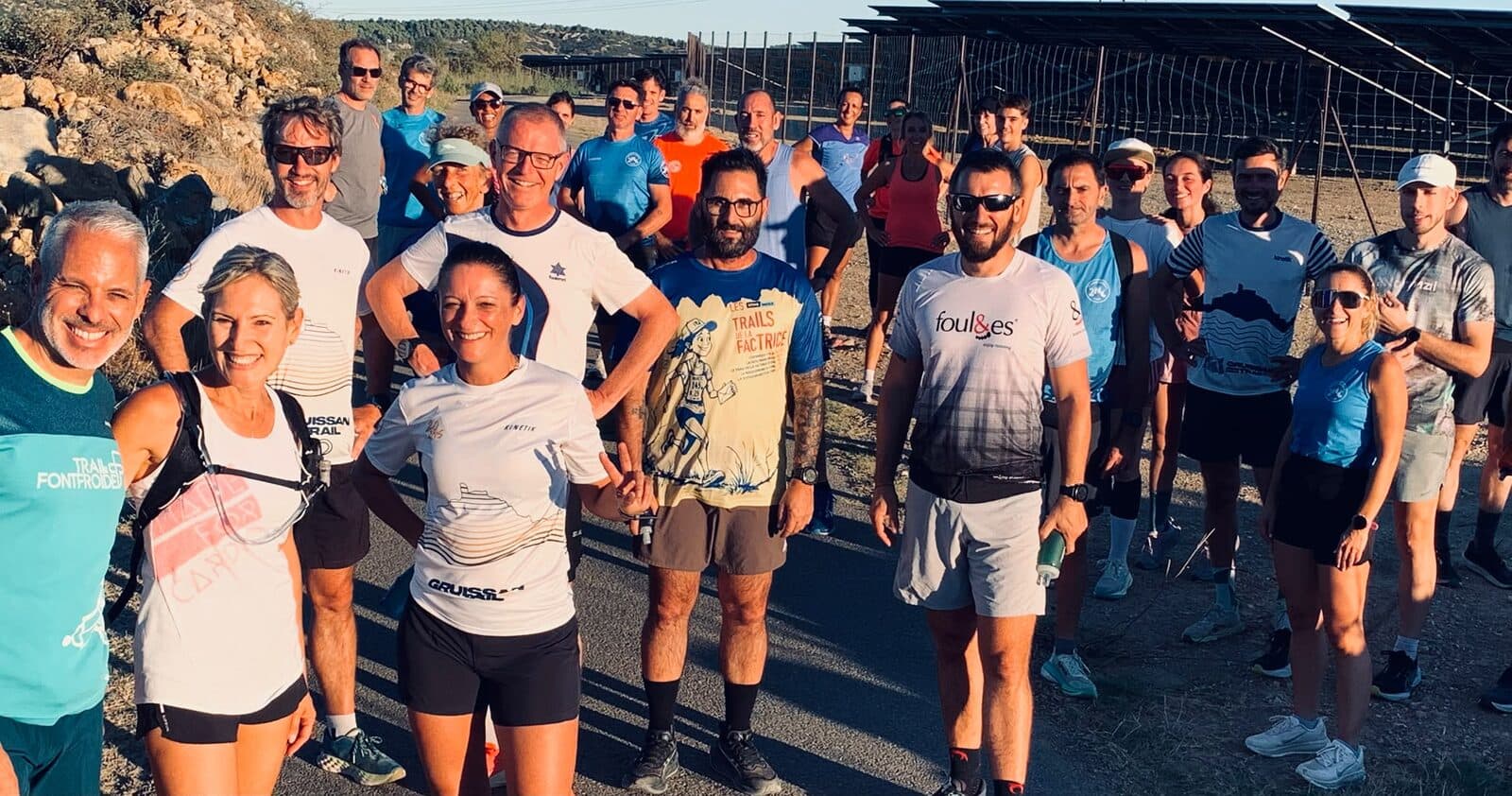 Un grand groupe de coureurs du club souriants avant une séance de côtes