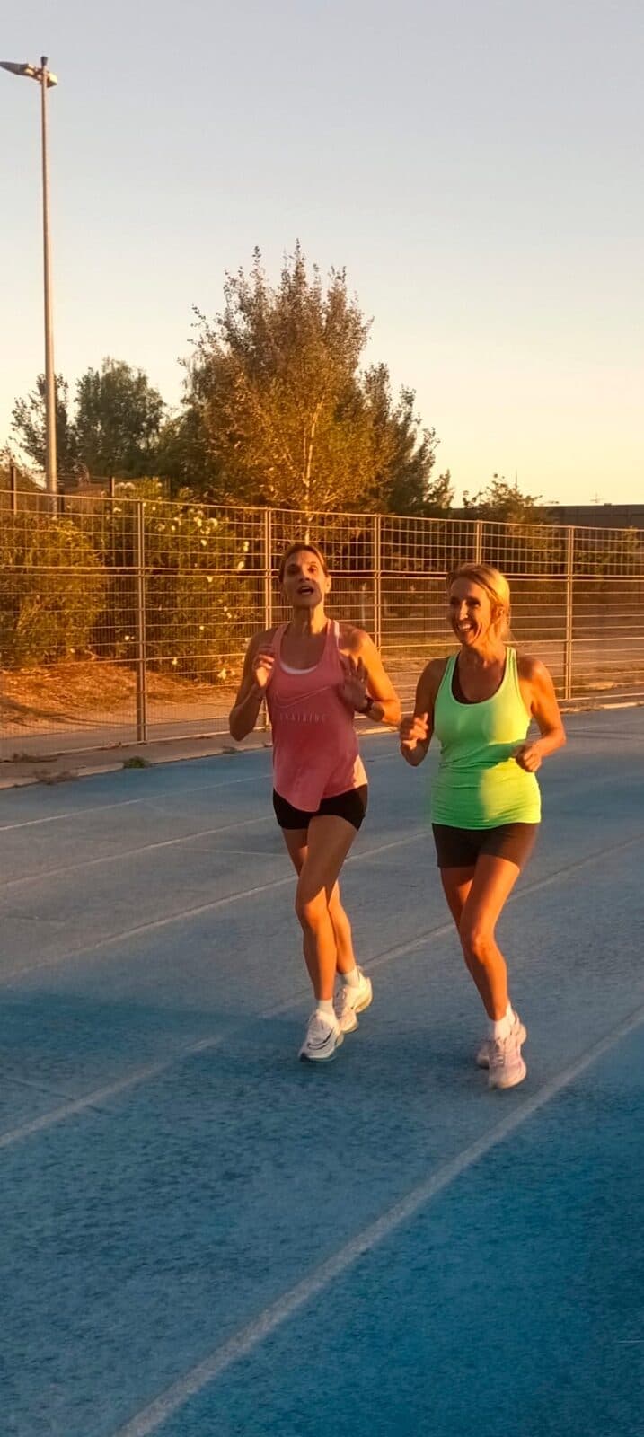 Deux coureuses du club en pleine accélération sur la piste au coucher du soleil
