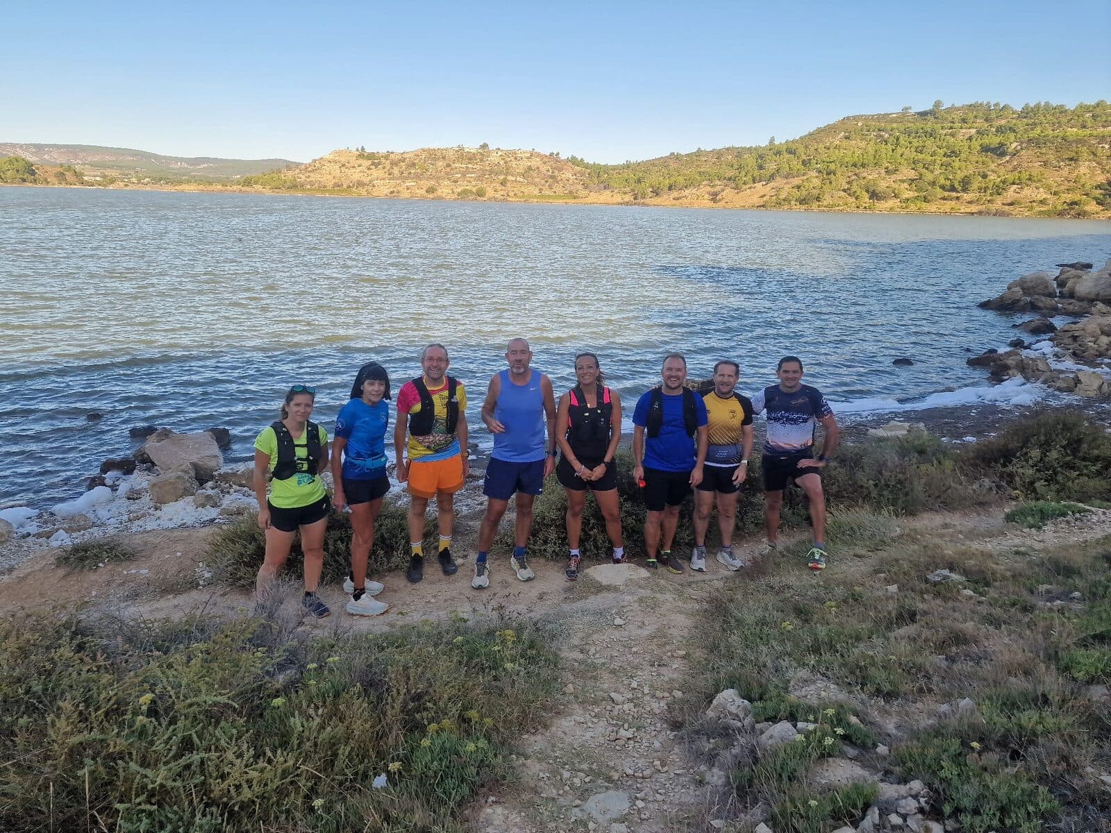 Le groupe Essentiel pose au bord de l'étang, collines en arrière-plan