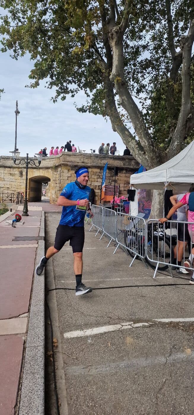 Un coureur du Narbo Nordik Club, bandeau sur le front, sur les quais de Narbonne