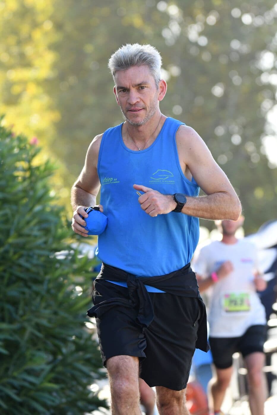 Un coureur du Narbo Nordik Club en débardeur bleu, le long du canal