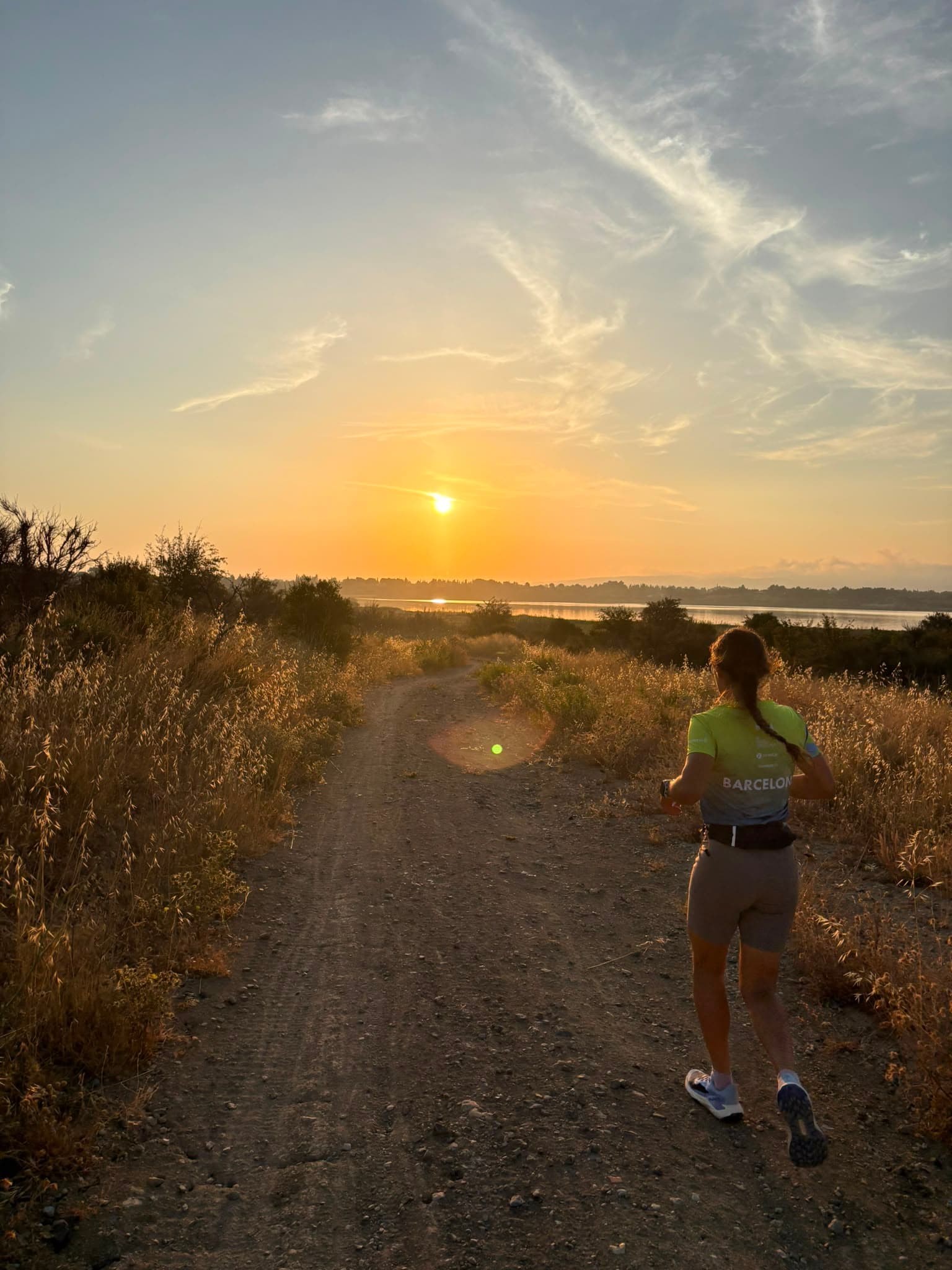 Coureuse face à l'étang au coucher du soleil